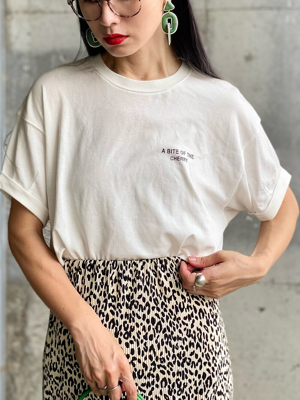ホワイト系のTシャツ/カットソー、ホワイト系のスカート、グリーン系のバッグを着用したレディースの夏コーディネートの2枚目の写真