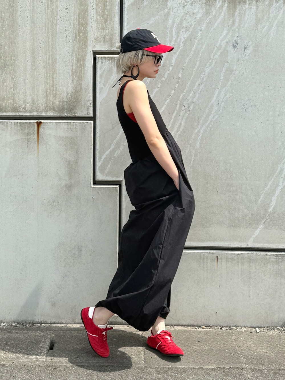 ブラック系のワンピース、レッド系のキャミソール、レッド系のスニーカーを着用したレディースの春コーディネートの2枚目の写真