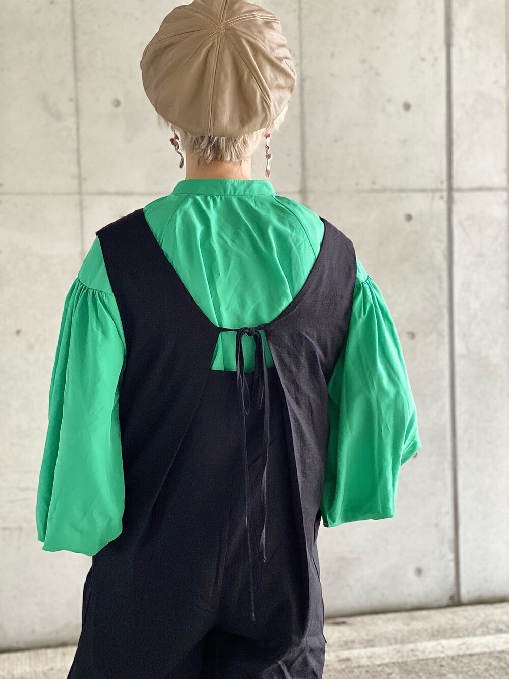 ブラック系のサロペット/オーバーオール、ベージュ系のサンダル、グリーン系のシャツ/ブラウスを着用したレディースの春コーディネートの3枚目の写真