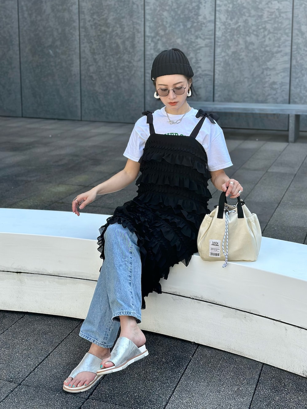 ブラック系のワンピース、ホワイト系のTシャツ/カットソー、ブルー系のデニムパンツを着用したレディースの春コーディネートの3枚目の写真