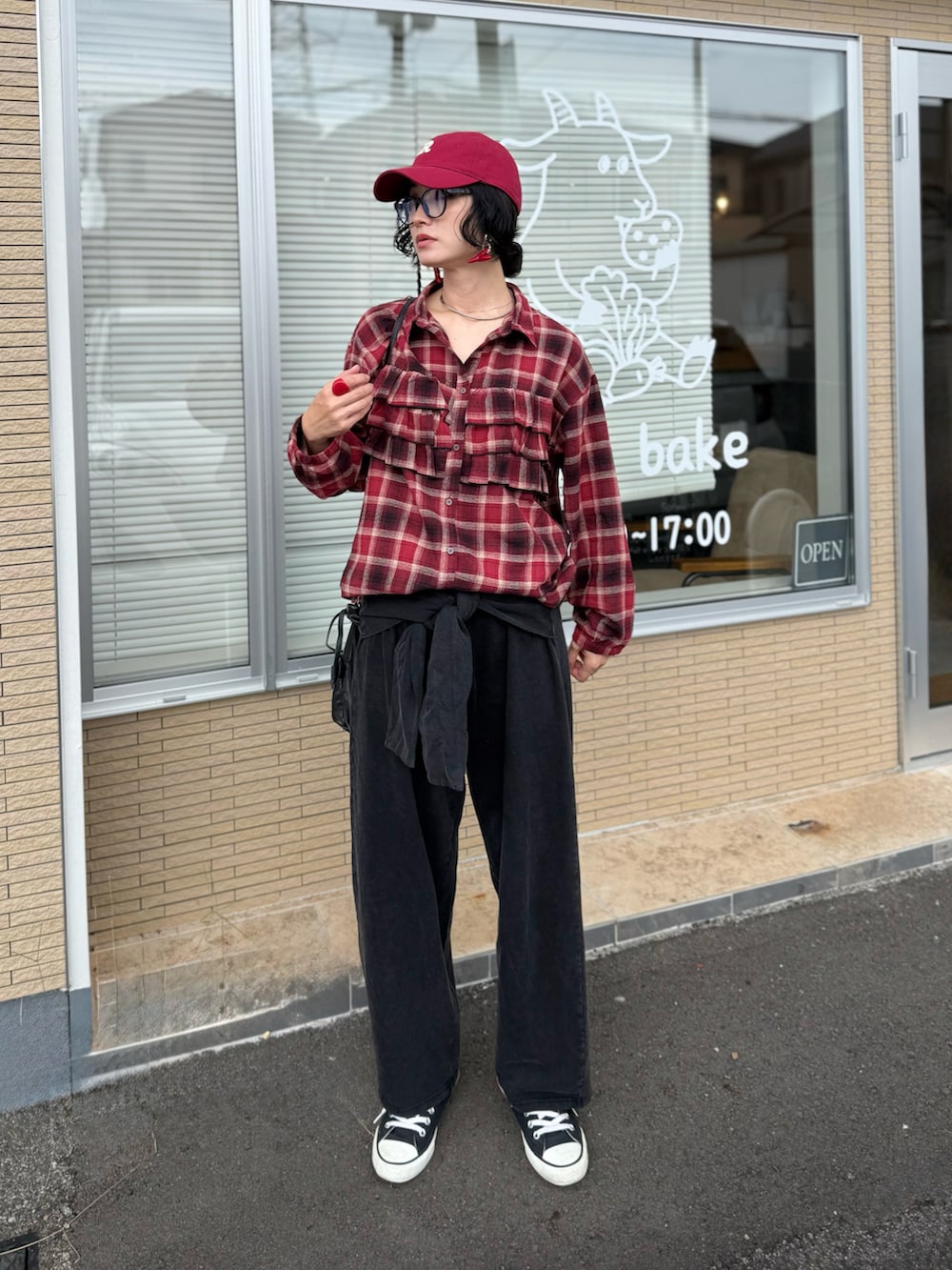 レッド系のシャツ/ブラウス、ブラック系のハンドバッグ、ブラック系のスウェットパンツを着用したレディースの秋コーディネートの2枚目の写真