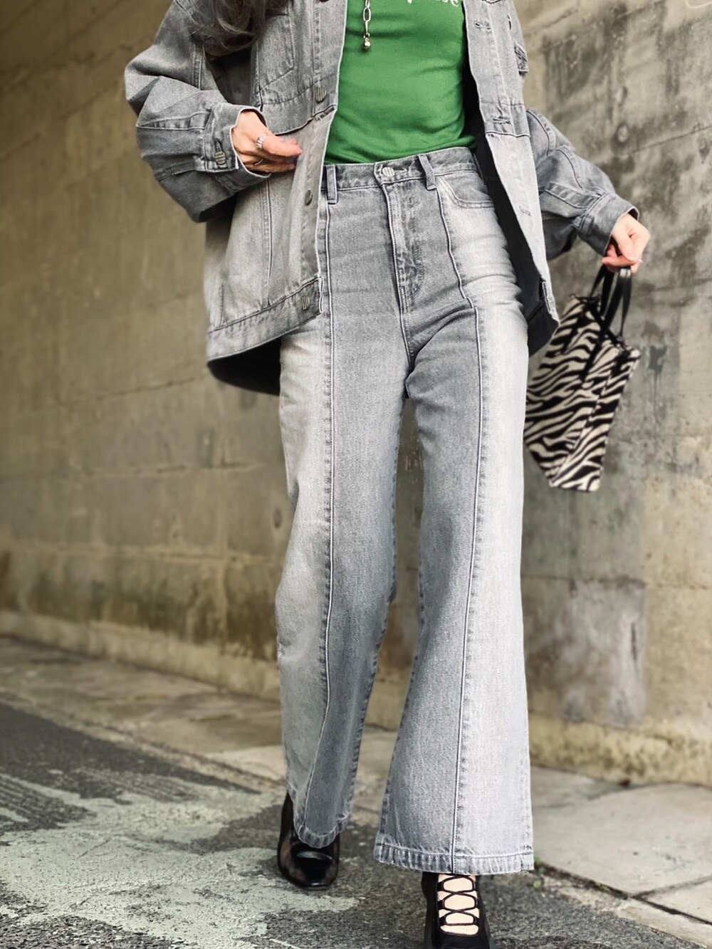 グレー系のデニムジャケット、グレー系のデニムパンツ、ブラック系のブーツを着用したレディースの冬コーディネートの3枚目の写真