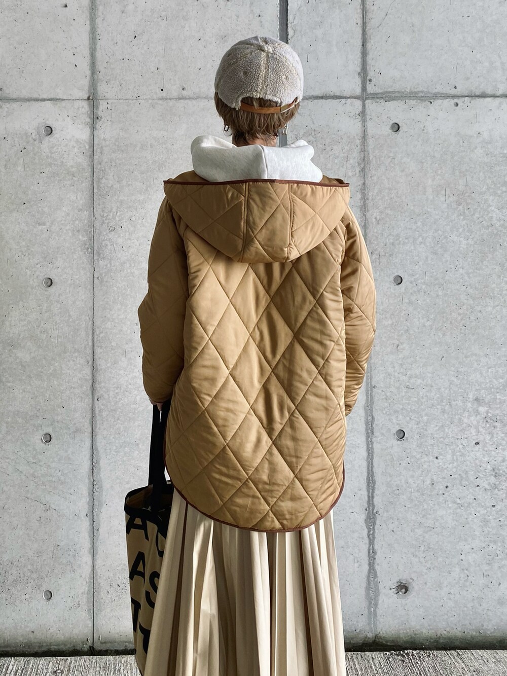 ベージュ系のその他アウター、ベージュ系のスカート、ベージュ系のトートバッグを着用したレディースの秋コーディネートの5枚目の写真