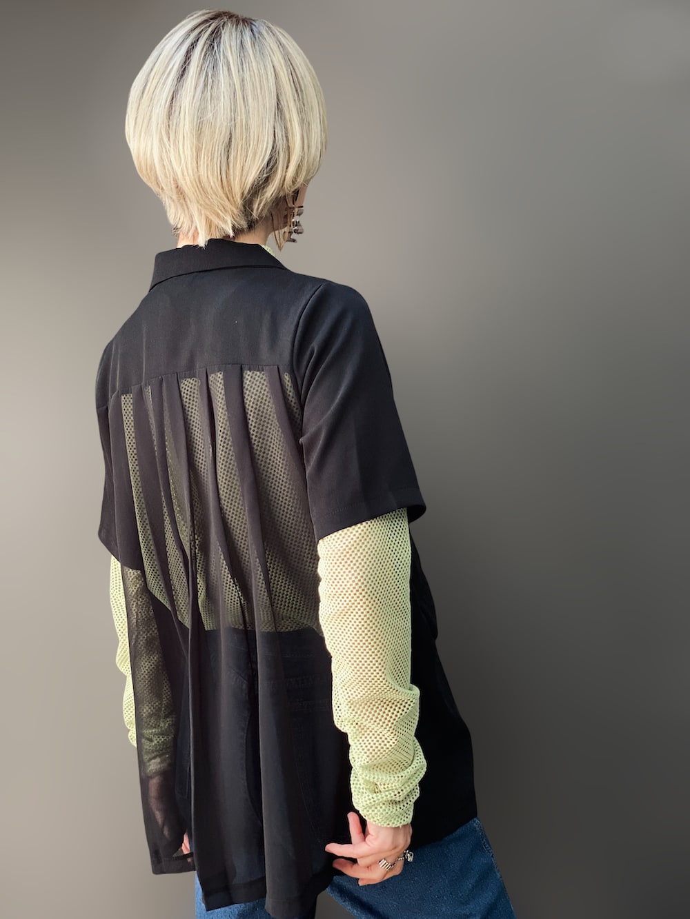 グリーン系のTシャツ/カットソー、ブラック系のテーラードジャケット、ブルー系のデニムパンツを着用したレディースの冬コーディネートの4枚目の写真