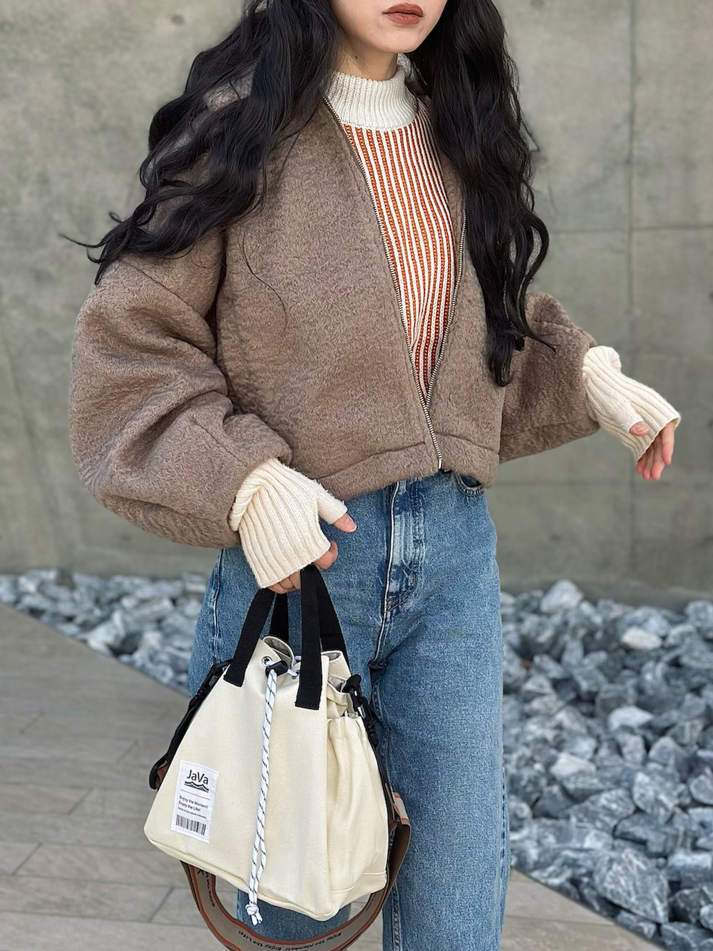 ベージュ系のブルゾン、オレンジ系のニット/セーター、ホワイト系のショルダーバッグを着用したレディースの冬コーディネートの4枚目の写真