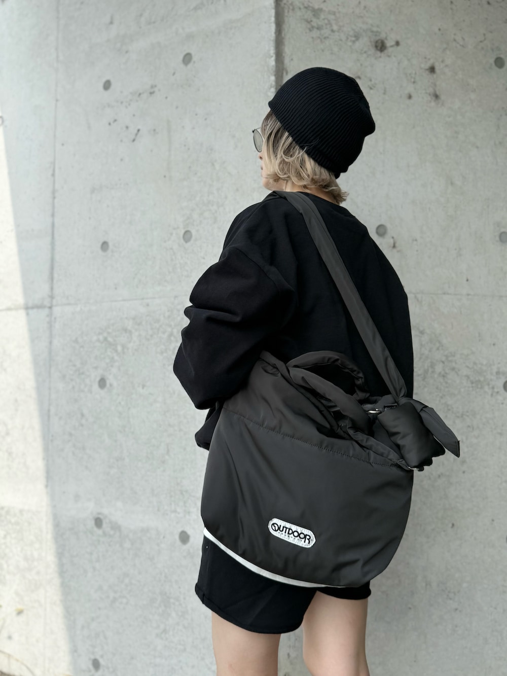 グレー系のスニーカー、グレー系のトートバッグ、ブラック系のセットアップを着用したレディースの秋コーディネートの4枚目の写真