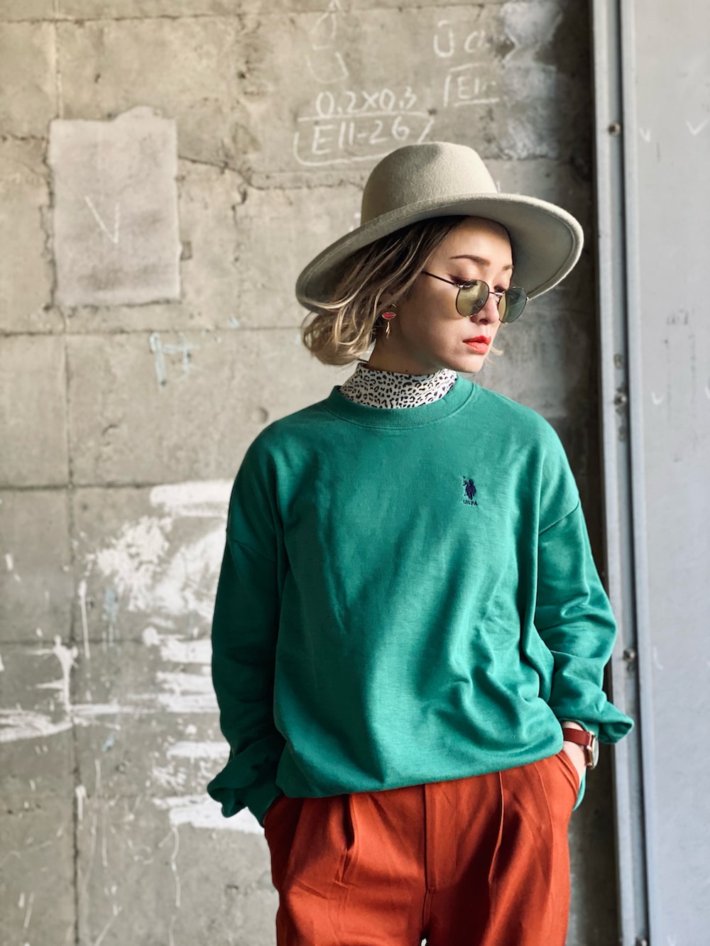 グリーン系のスウェット、ホワイト系のダウンベスト、ベージュ系のボストンバッグを着用したレディースの冬コーディネートの2枚目の写真