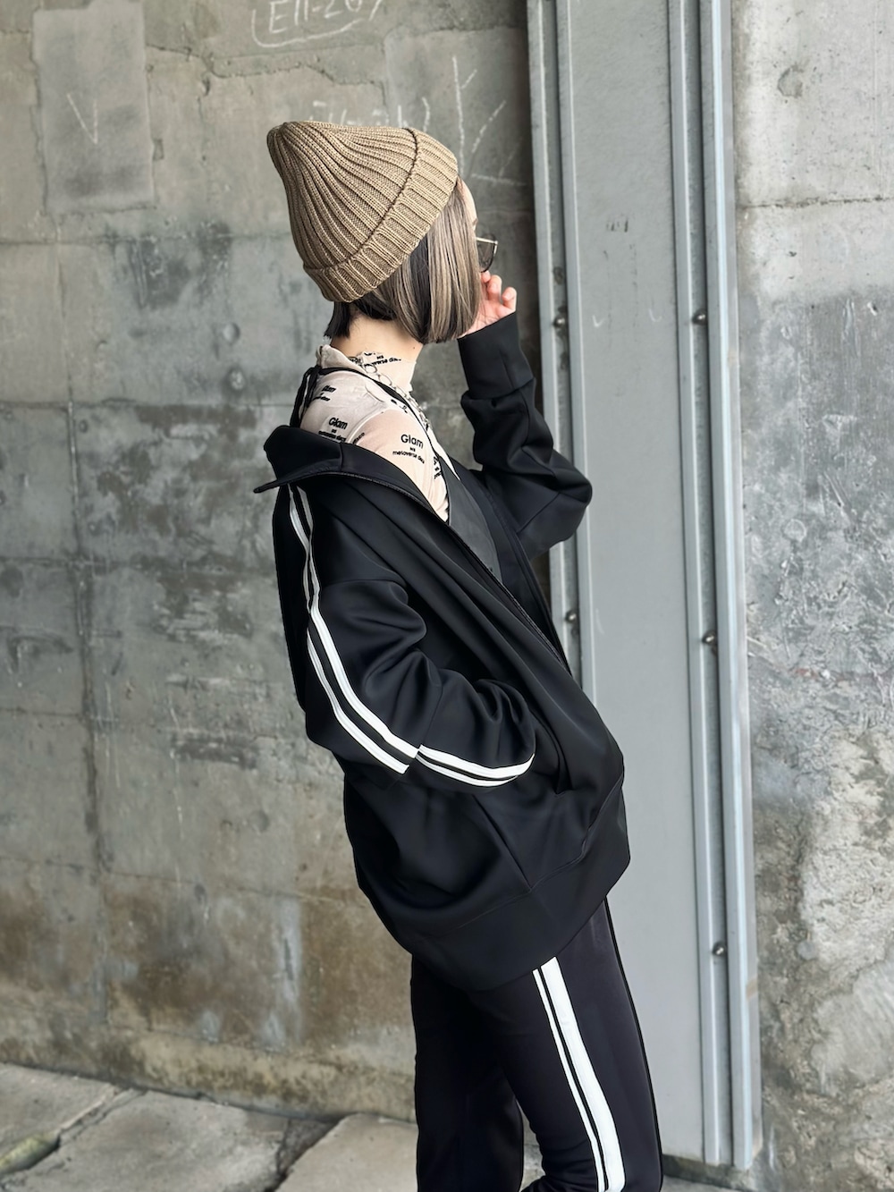 ブラック系のジャージ、ブラック系のスウェットパンツ、ベージュ系のTシャツ/カットソーを着用したレディースの夏コーディネートの3枚目の写真