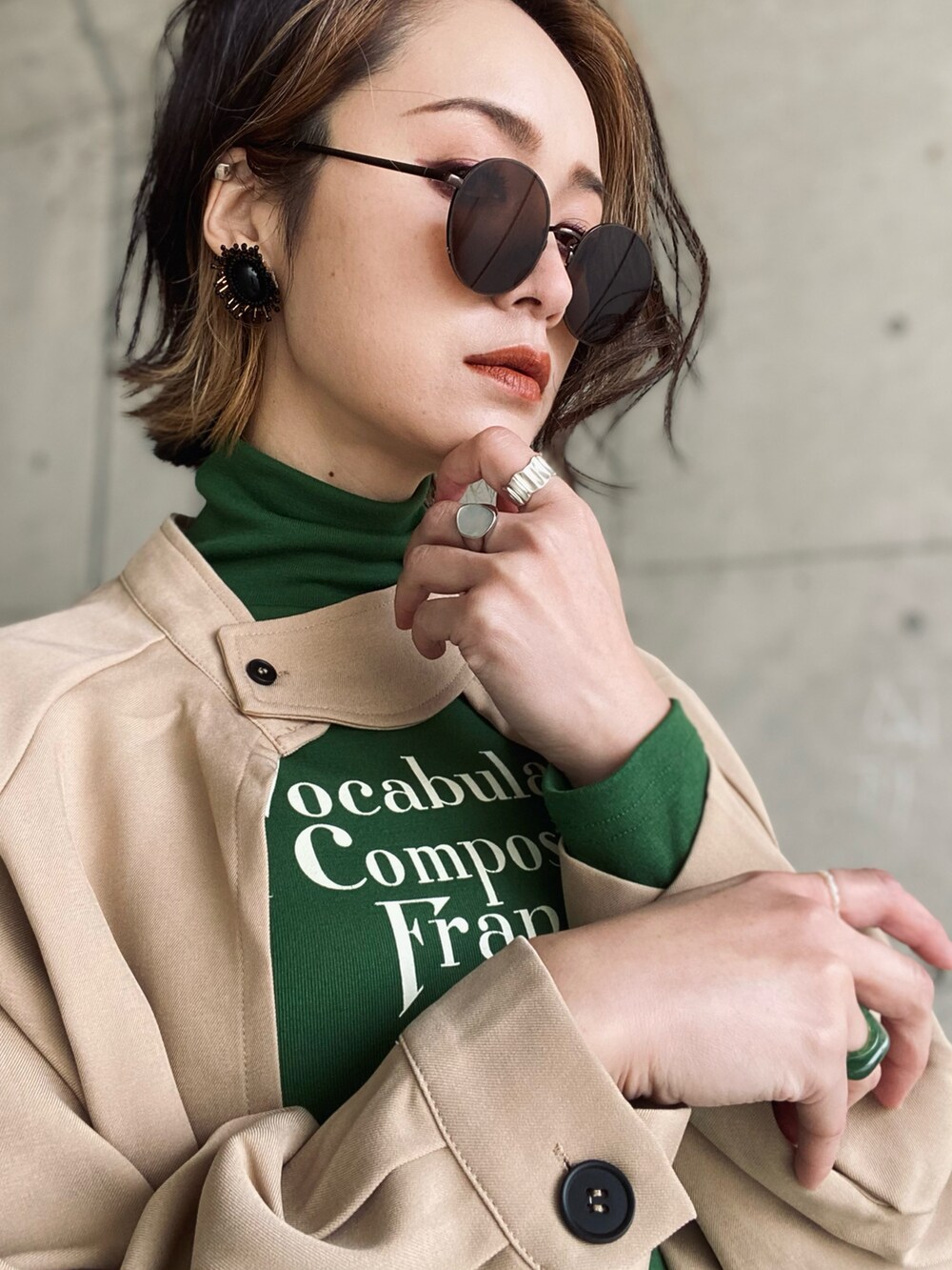 ベージュ系のトレンチコート、ブルー系のデニムパンツ、ブラウン系のハンドバッグを着用したレディースの冬コーディネートの5枚目の写真