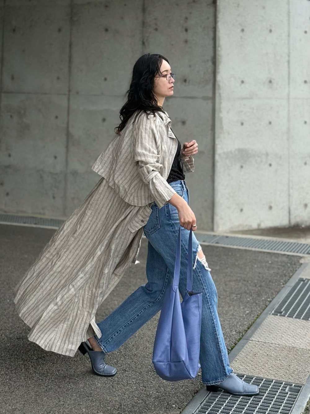 ブラック系のタンクトップ、ブルー系のサンダル、グレー系のトレンチコートを着用したレディースの春コーディネートの5枚目の写真