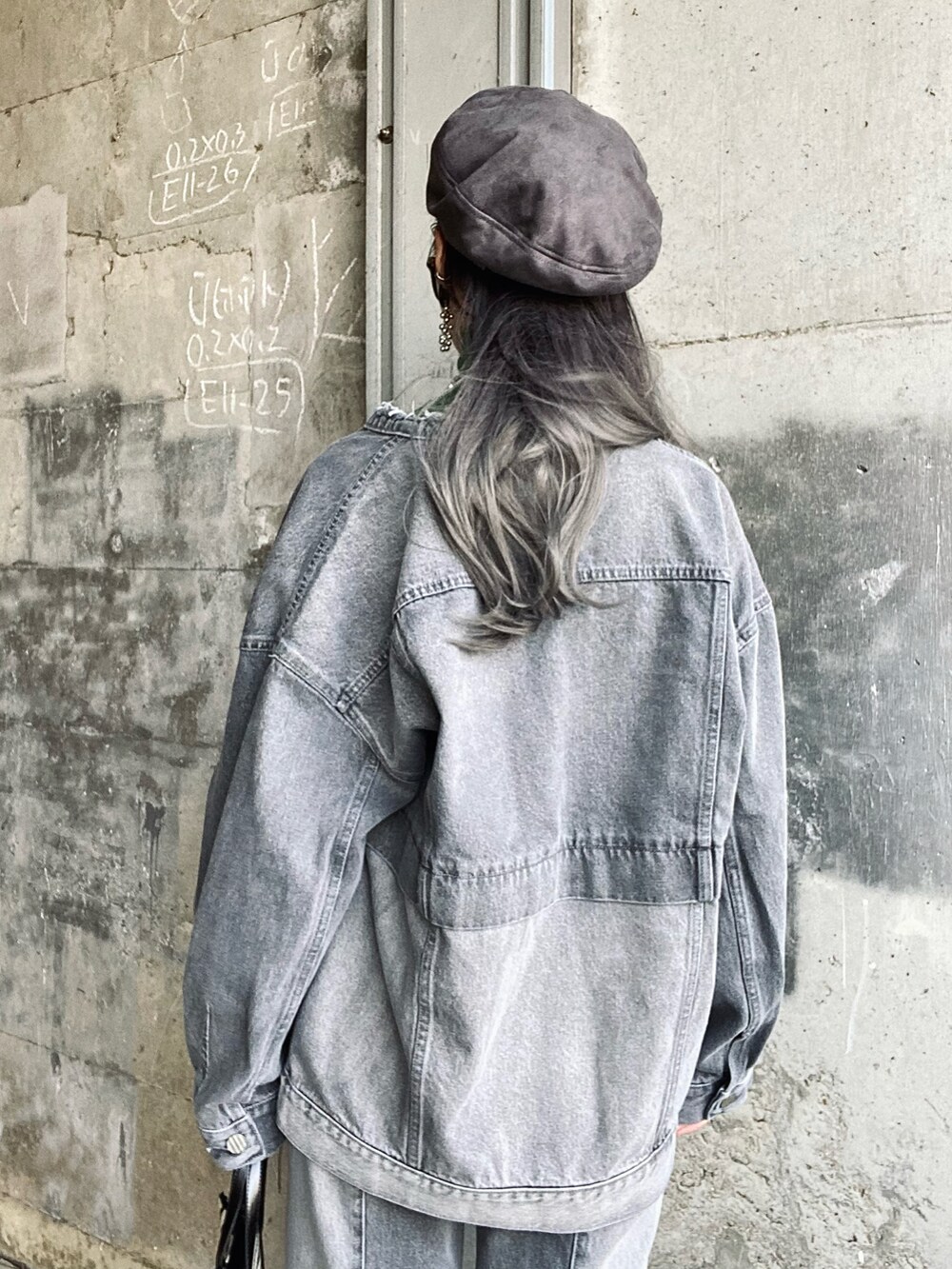 グレー系のデニムジャケット、グレー系のデニムパンツ、ブラック系のブーツを着用したレディースの冬コーディネートの4枚目の写真