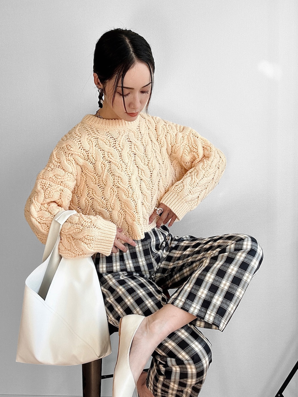 ホワイト系のトートバッグ、ホワイト系のパンプス、ブラック系のスラックスを着用したレディースの秋コーディネートの2枚目の写真