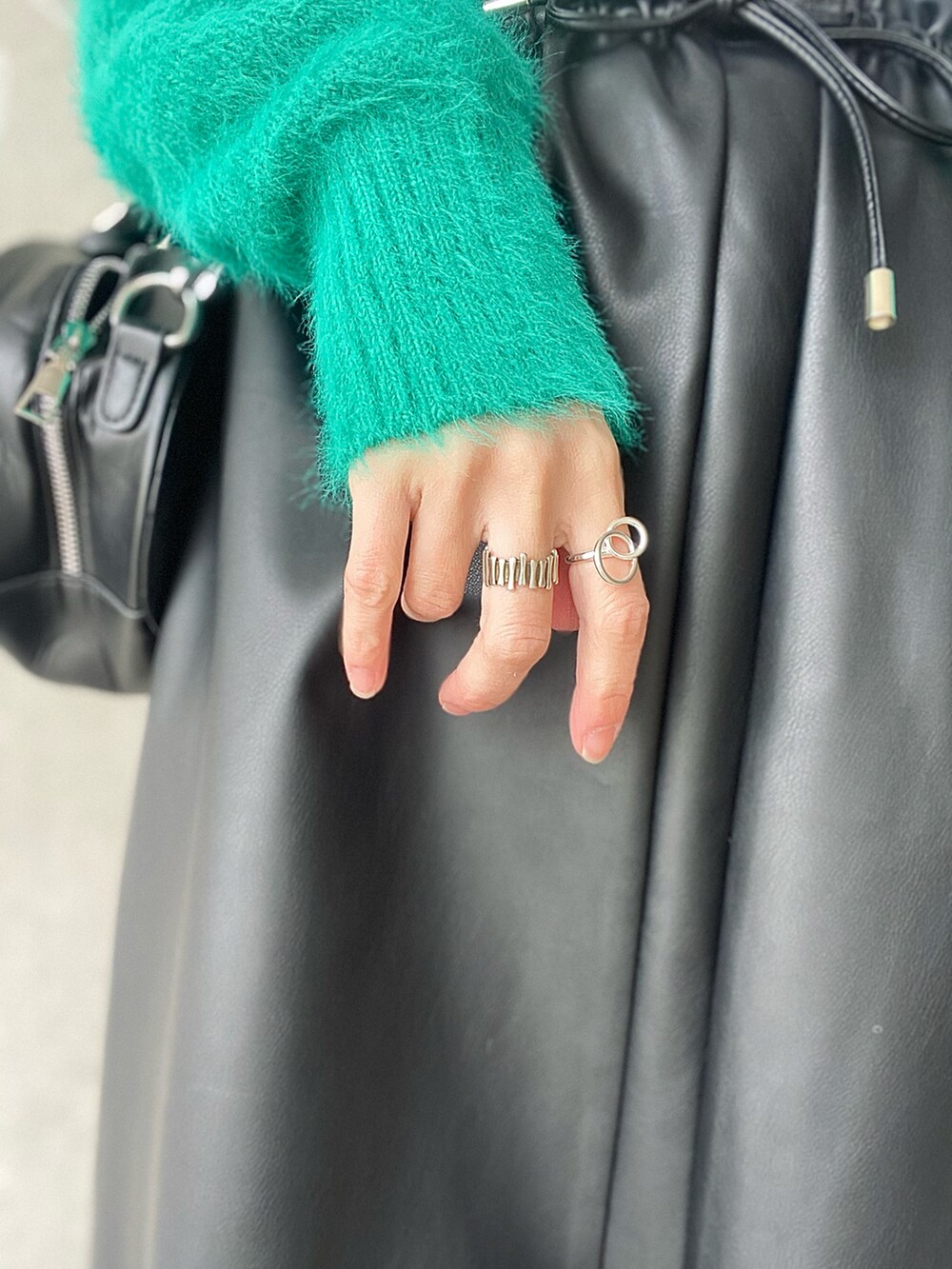 ブラック系のスカート、グリーン系のカーディガン/ボレロ、ブラック系のショルダーバッグを着用したレディースの冬コーディネートの5枚目の写真