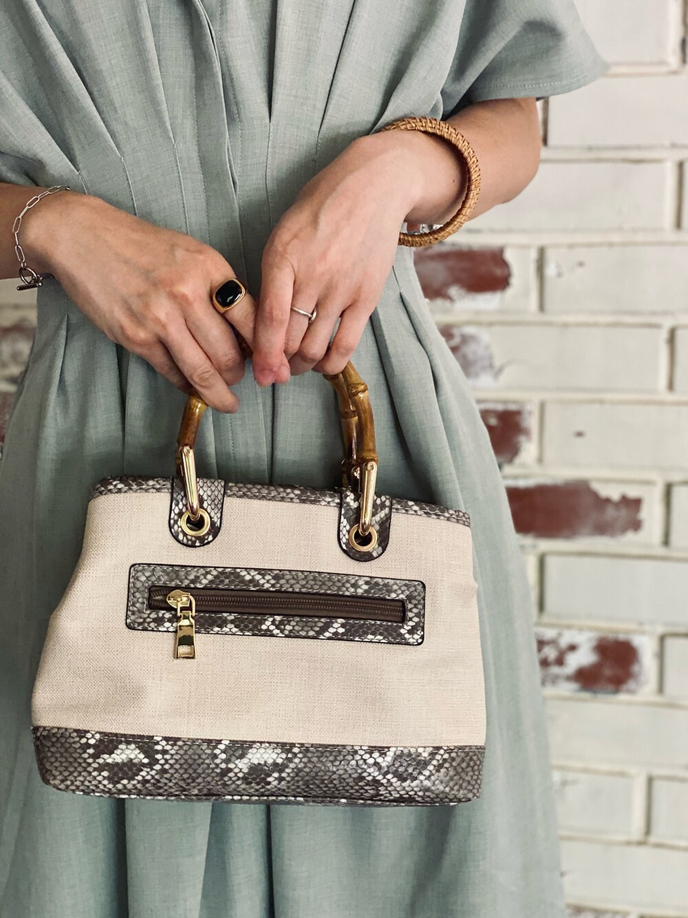 グリーン系のワンピース、その他のトートバッグ、ゴールド系のリングを着用したレディースの春コーディネートの2枚目の写真