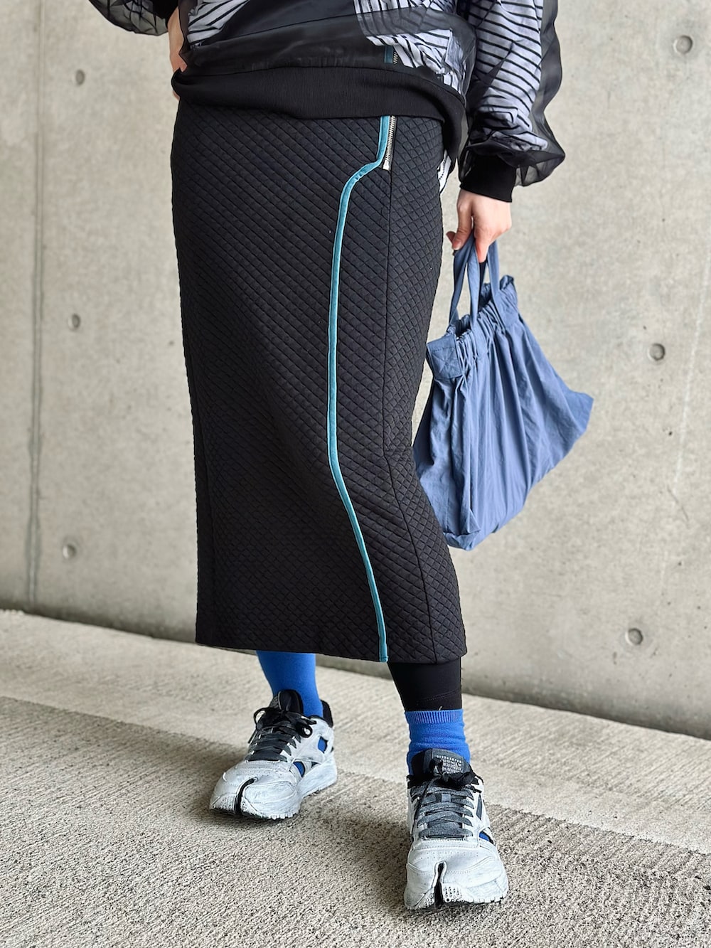 ブラック系のスカート、ブラック系のTシャツ/カットソー、ホワイト系のTシャツ/カットソーを着用したレディースの冬コーディネートの2枚目の写真