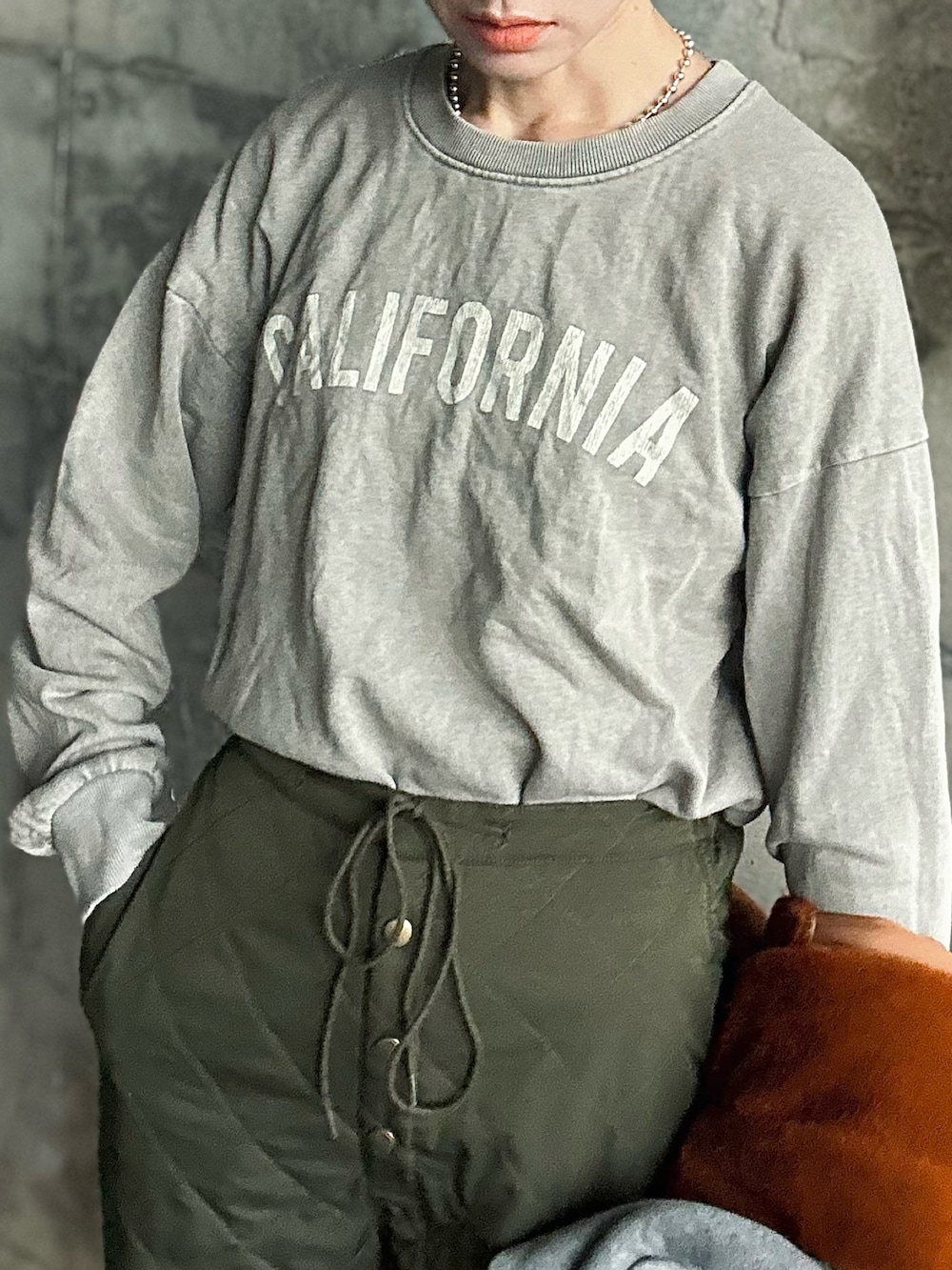 グリーン系のカーゴパンツ、イエロー系のブルゾン、ブラック系のその他トップスを着用したレディースの冬コーディネートの4枚目の写真