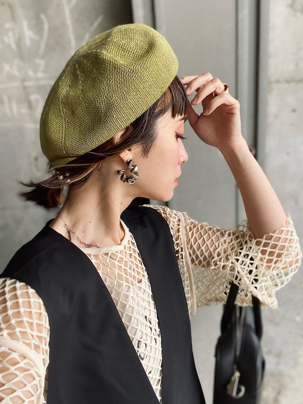 ブラック系のベスト、グリーン系のその他パンツ、ブラック系のサンダルを着用したレディースの春コーディネートの4枚目の写真