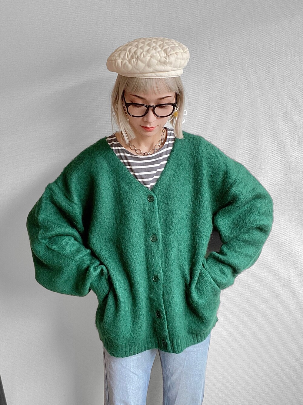 グリーン系のカーディガン/ボレロ、ブルー系のデニムパンツ、ベージュ系のスニーカーを着用したレディースの秋コーディネートの3枚目の写真