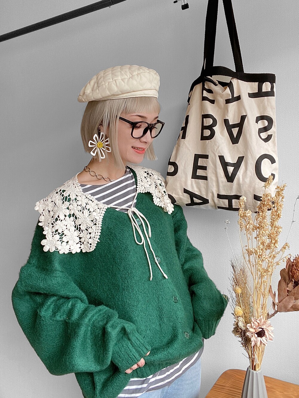 グリーン系のカーディガン/ボレロ、ブルー系のデニムパンツ、ベージュ系のスニーカーを着用したレディースの秋コーディネートの2枚目の写真