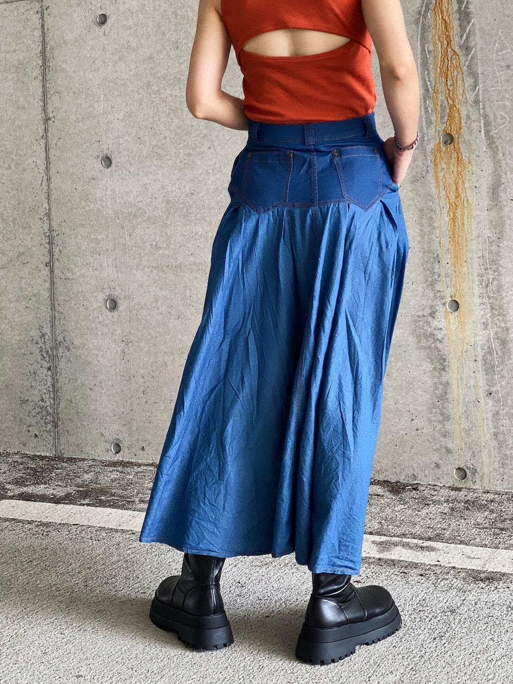 ブラック系のMA-1、ブルー系のデニムスカート、オレンジ系のタンクトップを着用したレディースの秋コーディネートの4枚目の写真