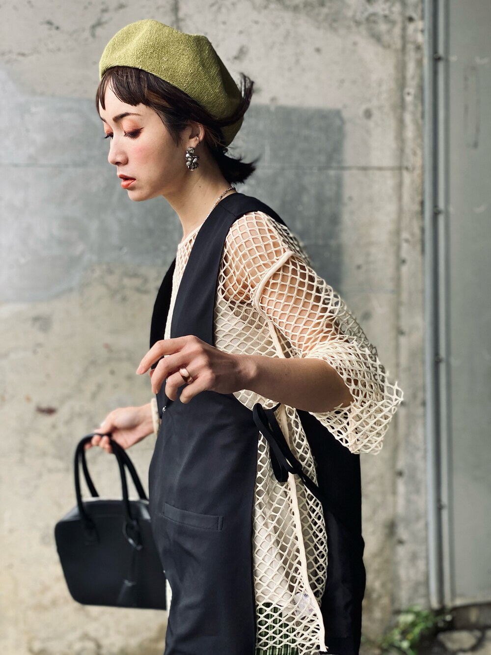 ブラック系のベスト、グリーン系のその他パンツ、ブラック系のサンダルを着用したレディースの春コーディネートの2枚目の写真