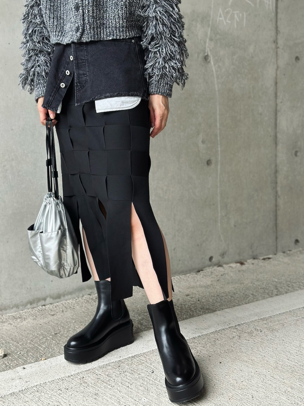 ブラック系のブーツ、ブラック系のカーディガン/ボレロ、シルバー系のハンドバッグを着用したレディースの秋コーディネートの5枚目の写真