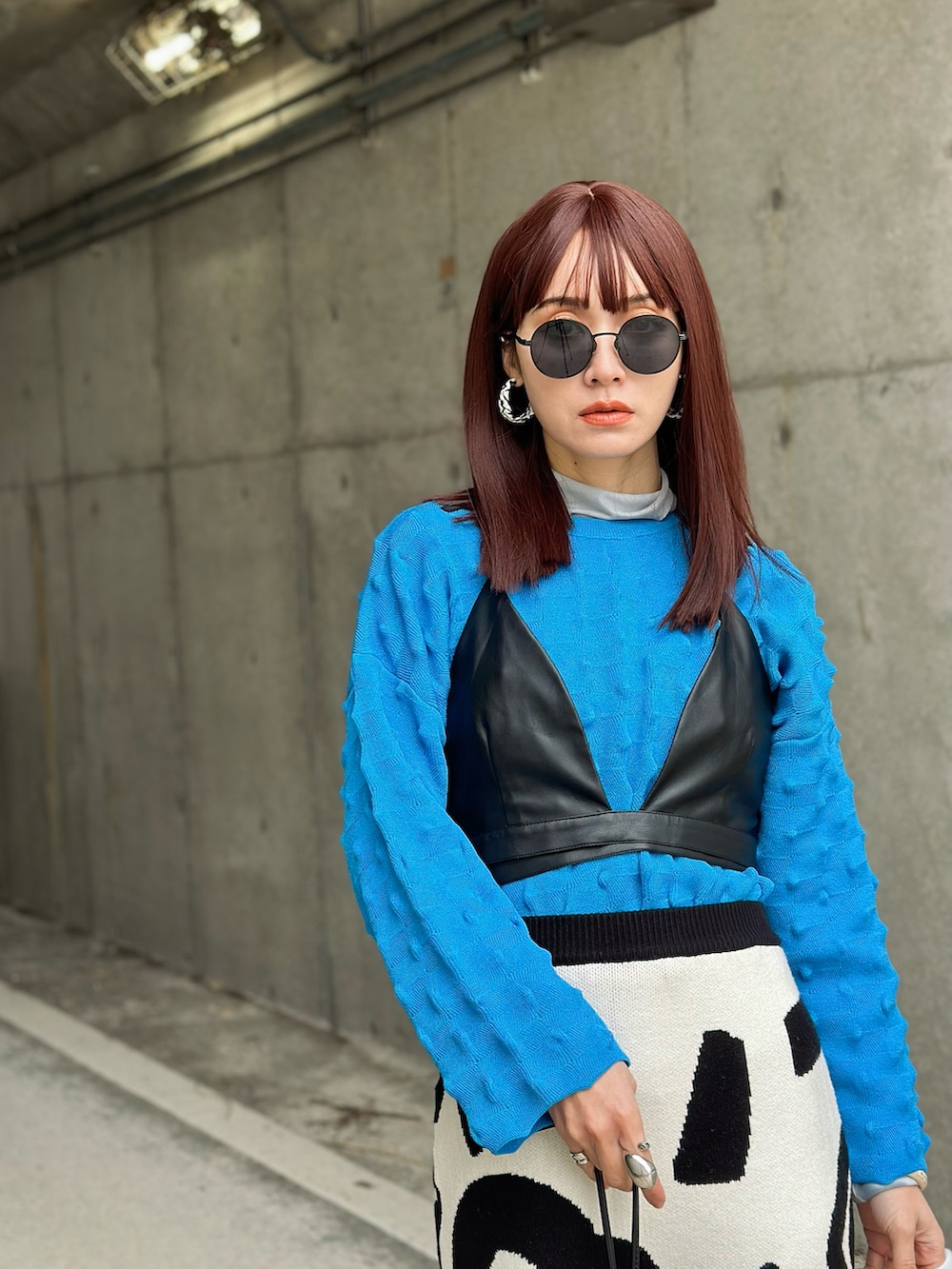 ブルー系のニット/セーター、ホワイト系のスカート、ベージュ系のTシャツ/カットソーを着用したレディースの冬コーディネートの2枚目の写真