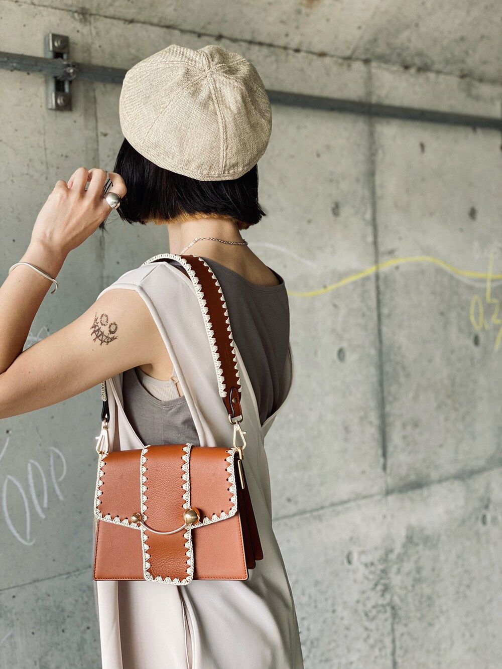 ホワイト系のタンクトップ、ホワイト系のワンピース、ブラウン系のショルダーバッグを着用したレディースの夏コーディネートの4枚目の写真