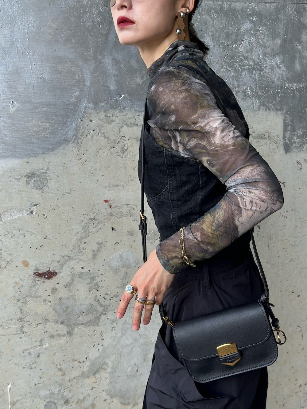 ブラック系のTシャツ/カットソー、ブラック系のメッセンジャーバッグ、ブラック系のパンプスを着用したレディースの秋コーディネートの3枚目の写真