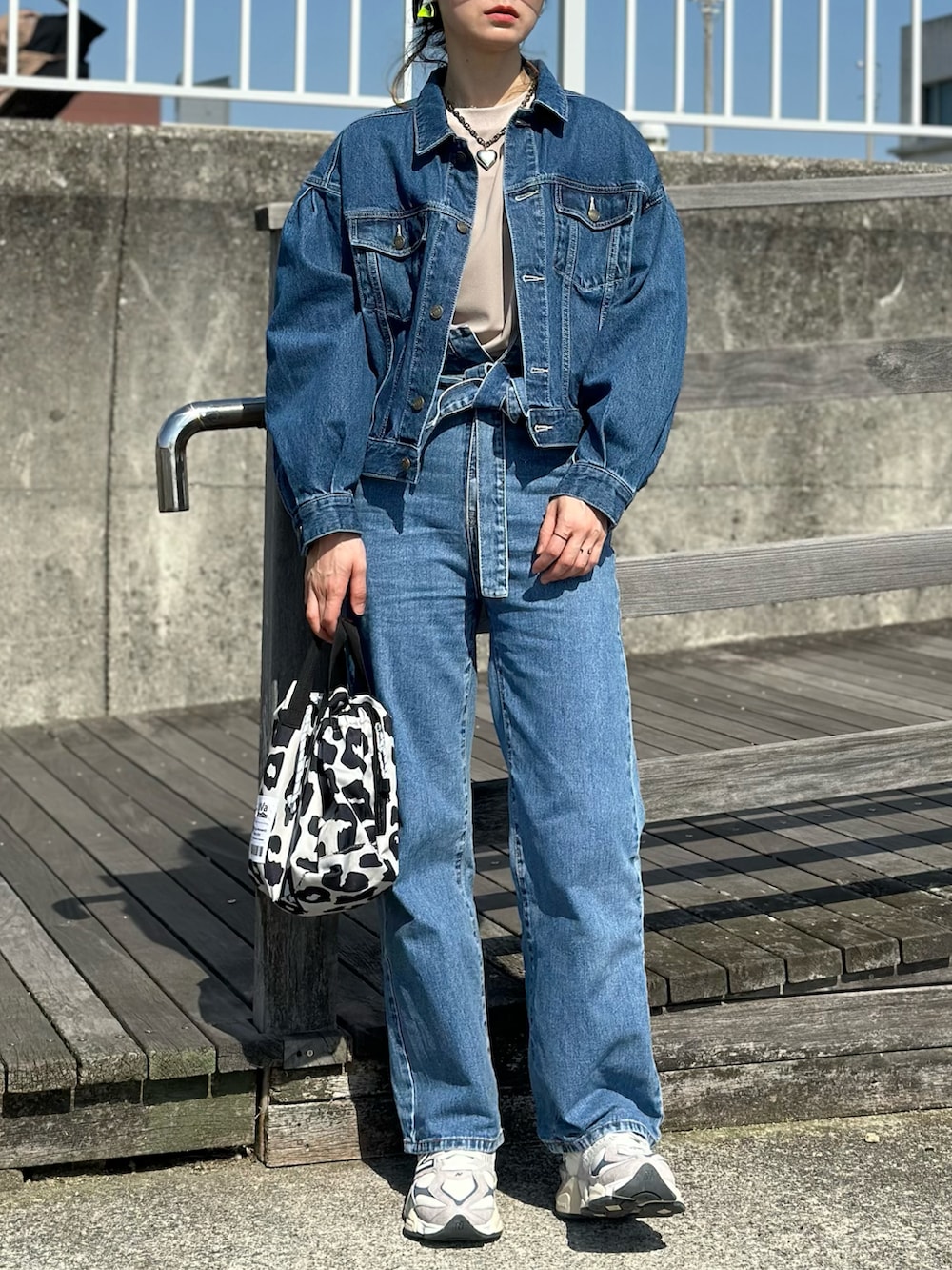 ベージュ系のTシャツ/カットソー、ブルー系のデニムジャケット、ベージュ系のスニーカーを着用したレディースの春コーディネートの3枚目の写真