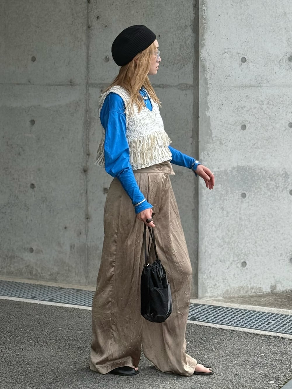 ブラック系のハンドバッグ、ブルー系のTシャツ/カットソー、ホワイト系のベストを着用したレディースの春コーディネートの4枚目の写真