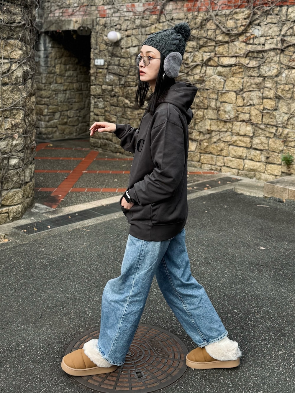 グレー系のパーカー、イエロー系のスリッポン、ブルー系のデニムパンツを着用したレディースの冬コーディネートの4枚目の写真