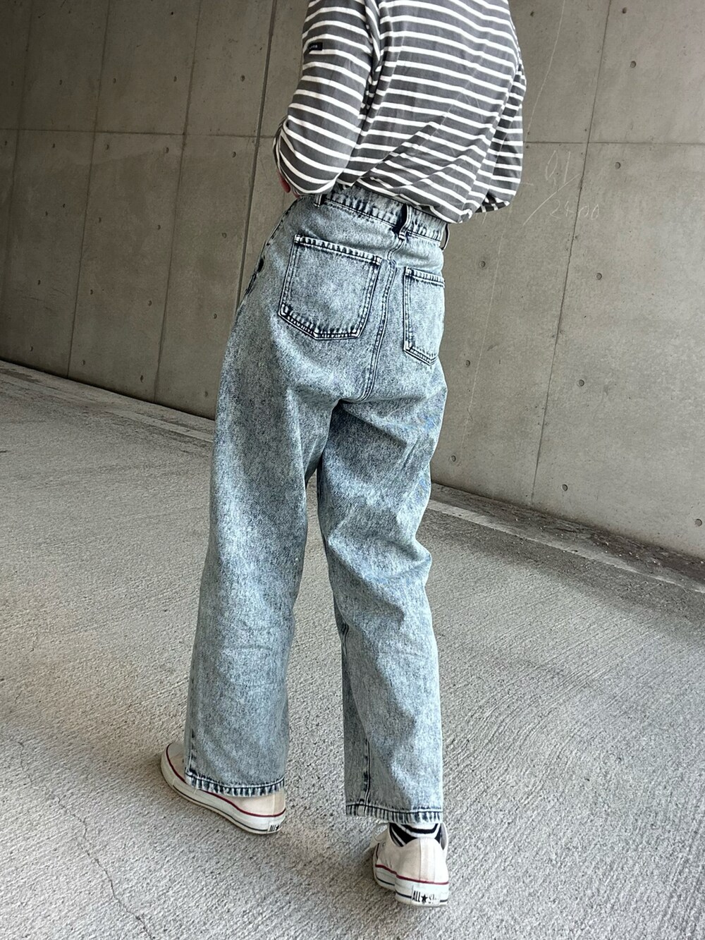 ホワイト系のトートバッグ、ブルー系のデニムパンツを着用したレディースの冬コーディネートの5枚目の写真