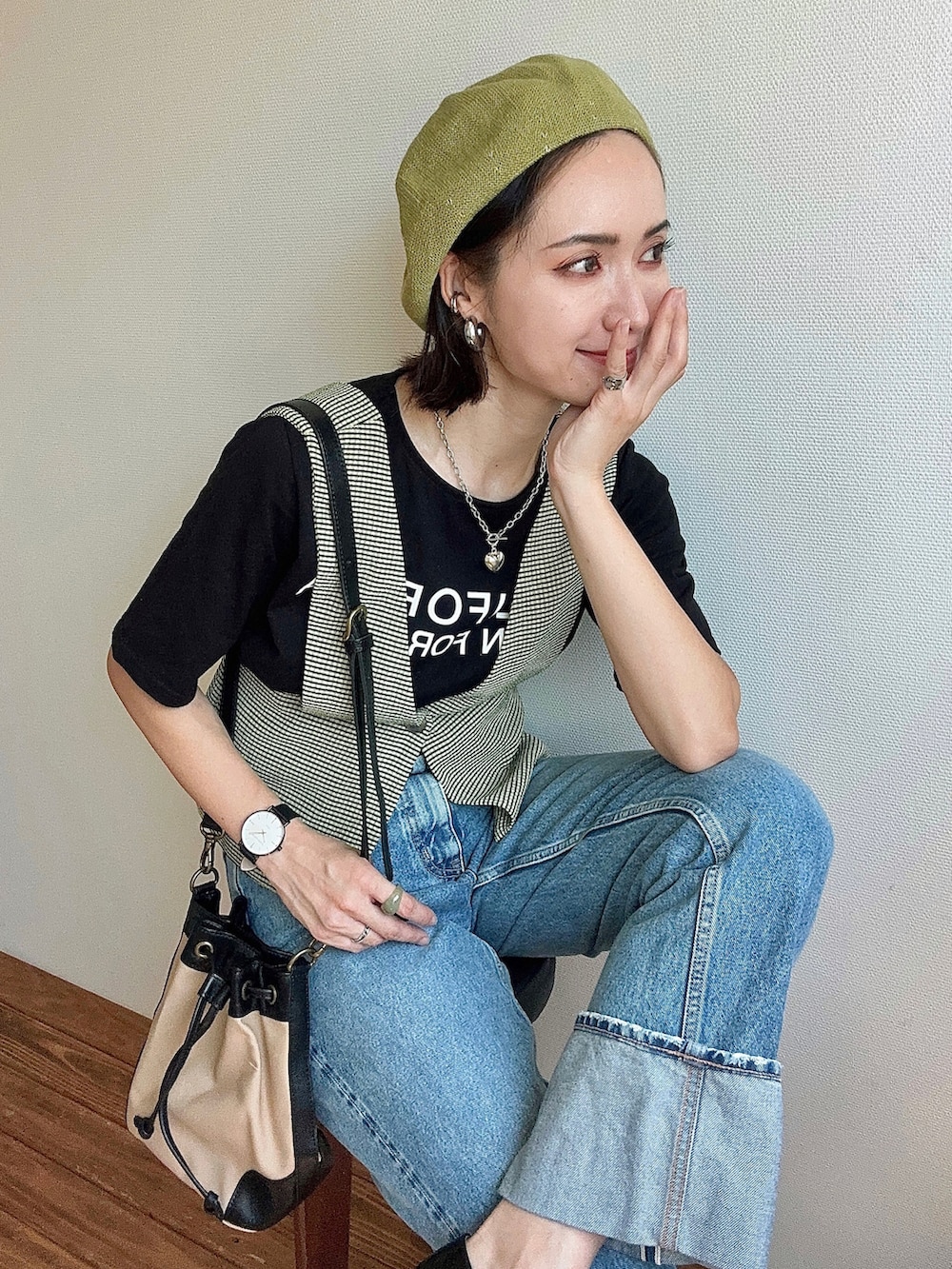 グリーン系のベスト、ブラック系のTシャツ/カットソー、ブルー系のデニムパンツを着用したレディースの夏コーディネートの5枚目の写真