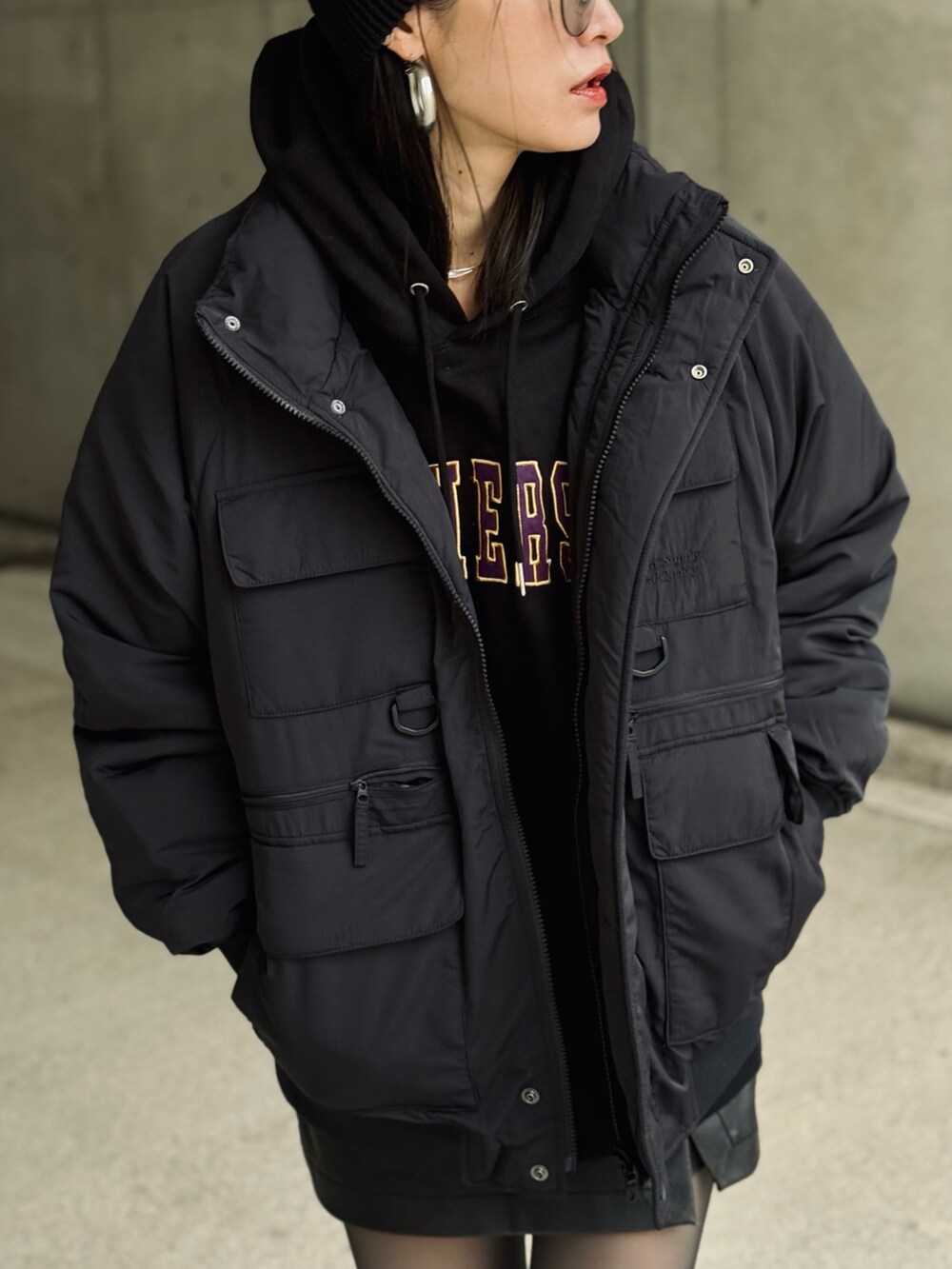 ブラック系のナイロンジャケット、パープル系のスニーカー、ブラック系のその他パンツを着用したレディースの秋コーディネートの2枚目の写真