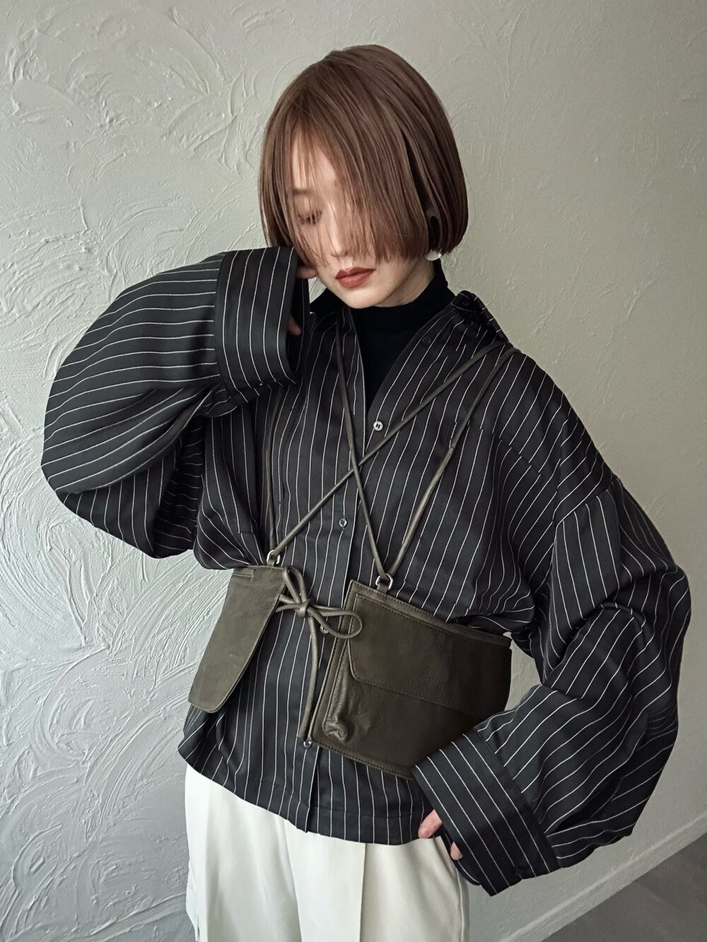 グレー系のシャツ/ブラウス、ホワイト系のカーゴパンツ、グレー系のハンドバッグを着用したレディースの冬コーディネートの2枚目の写真