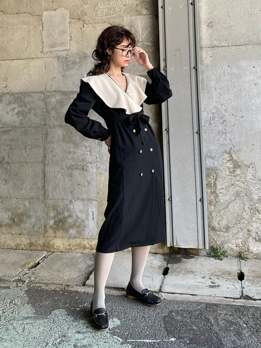 ブラック系のワンピース、グリーン系のハンドバッグ、ブラック系のローファーを着用したレディースの春コーディネートの3枚目の写真