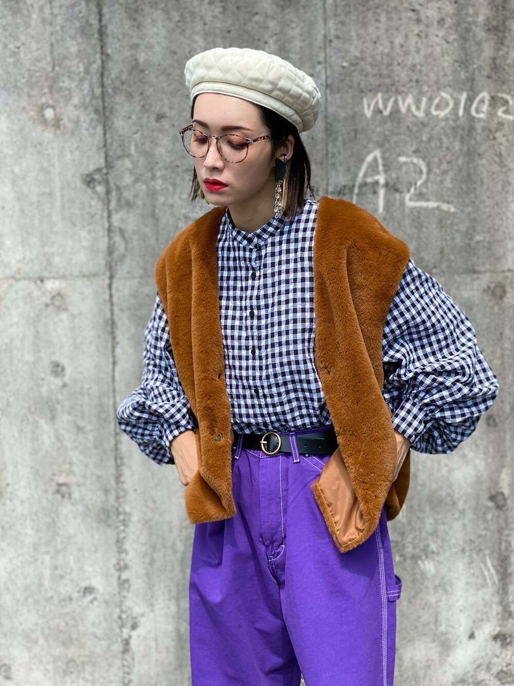 ブラック系のシャツ/ブラウス、イエロー系のベスト、パープル系のデニムパンツを着用したレディースの秋コーディネートの2枚目の写真