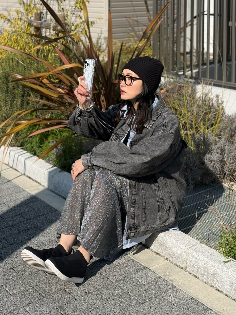 ブラック系のスニーカー、グレー系のTシャツ/カットソー、ブラック系のデニムジャケットを着用したレディースの春コーディネートの3枚目の写真