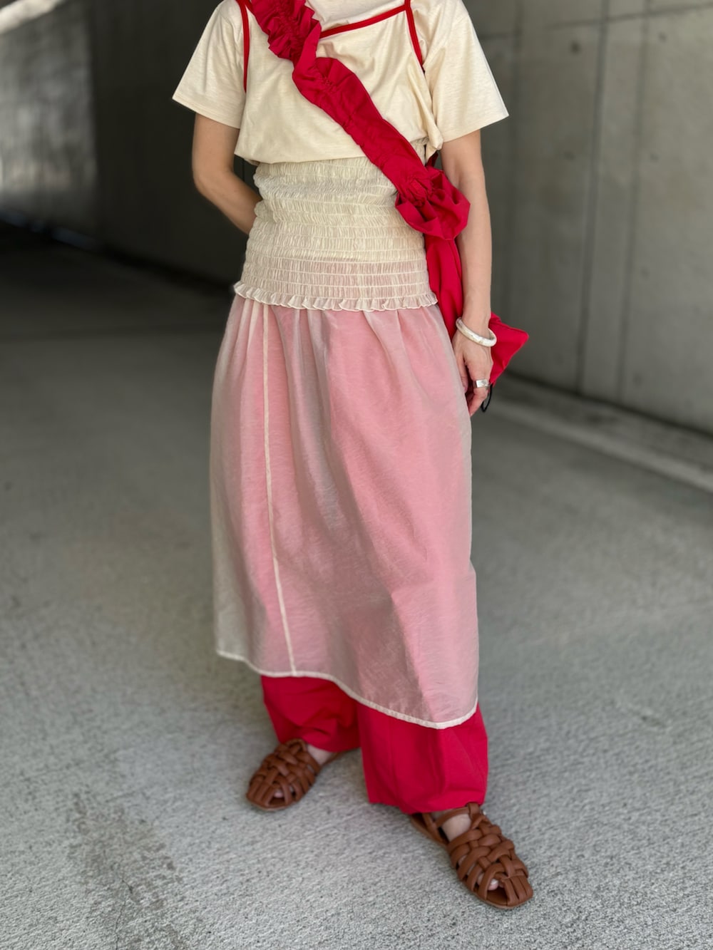 レッド系のショルダーバッグ、ベージュ系のTシャツ/カットソー、ベージュ系のスカートを着用したレディースの夏コーディネートの4枚目の写真