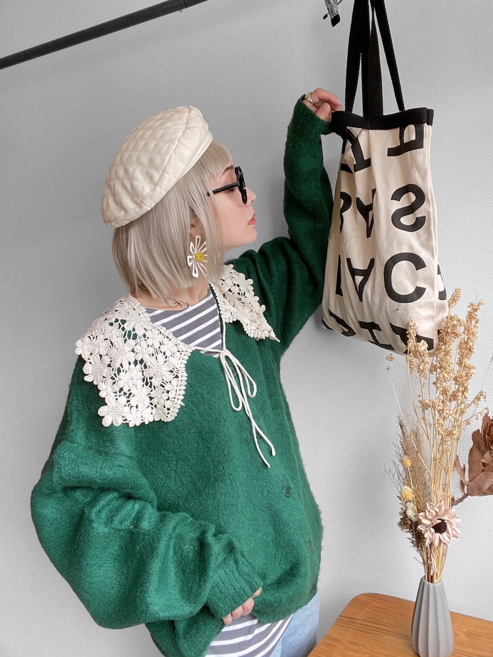 グリーン系のカーディガン/ボレロ、ブルー系のデニムパンツ、ベージュ系のスニーカーを着用したレディースの秋コーディネートの4枚目の写真