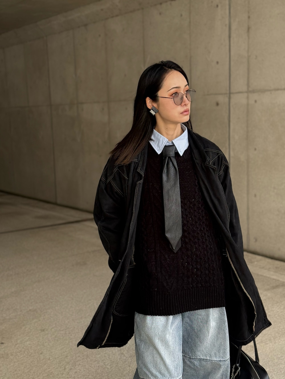 ブラック系のニット/セーター、ブルー系のデニムパンツ、その他のネクタイを着用したレディースの冬コーディネートの4枚目の写真