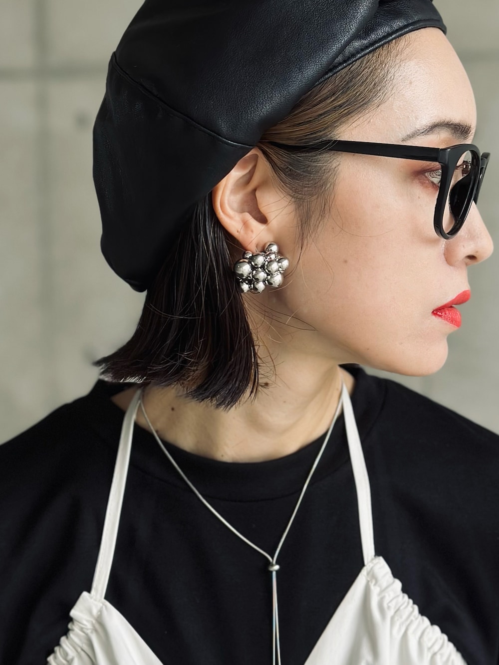 ホワイト系のベスト、ブラック系のその他トップス、シルバー系のトートバッグを着用したレディースの秋コーディネートの4枚目の写真