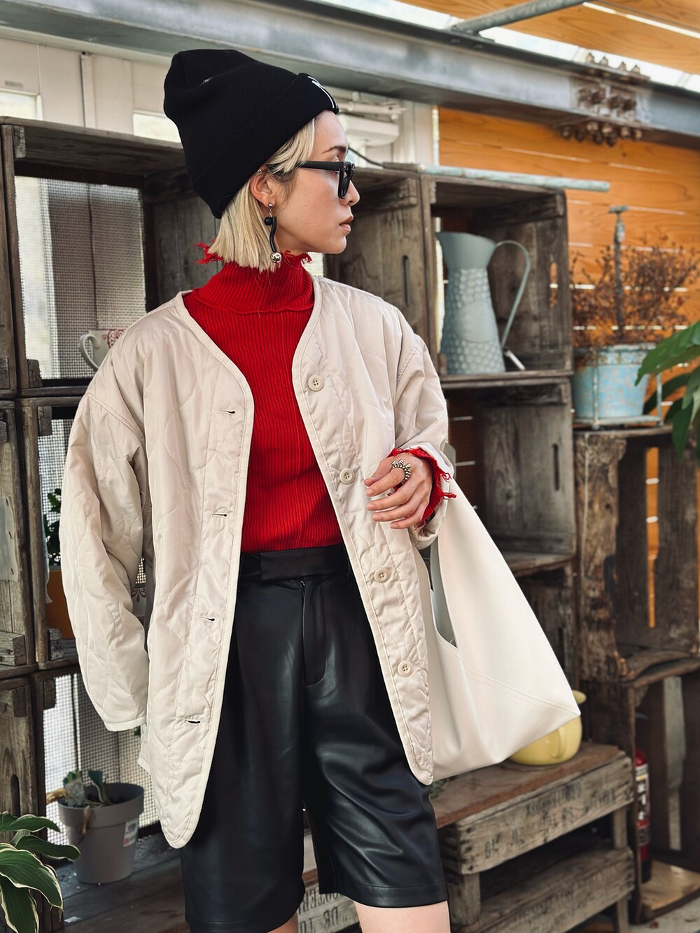 ホワイト系のトートバッグ、ホワイト系のブーツ、ブラック系のその他パンツを着用したレディースの秋コーディネートの2枚目の写真