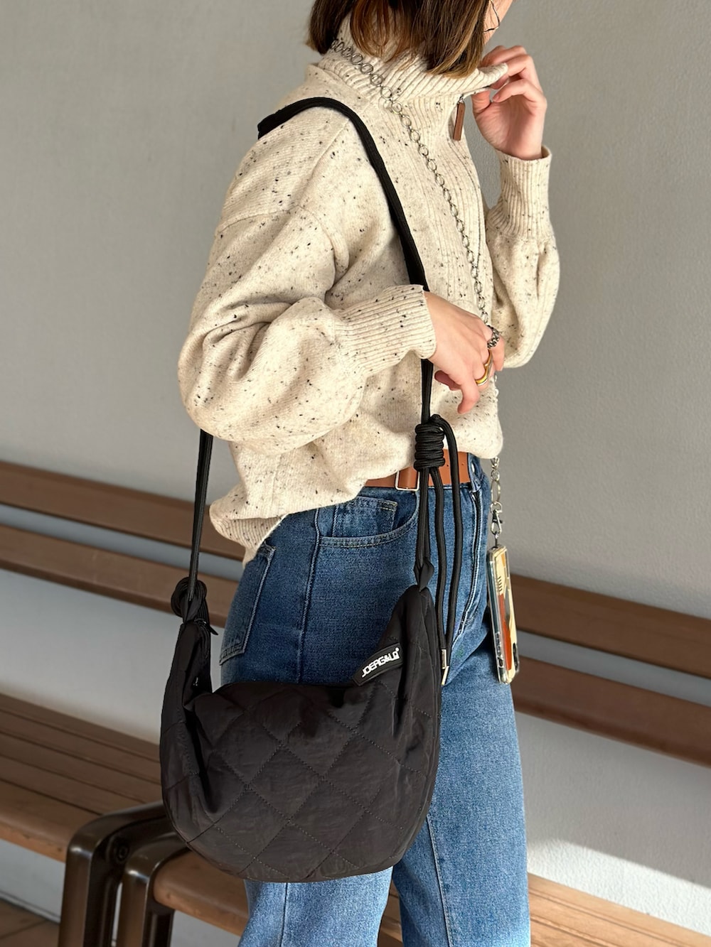 ホワイト系のニット/セーター、グリーン系のジャケット/アウター、ブルー系のデニムパンツを着用したレディースの春コーディネートの4枚目の写真