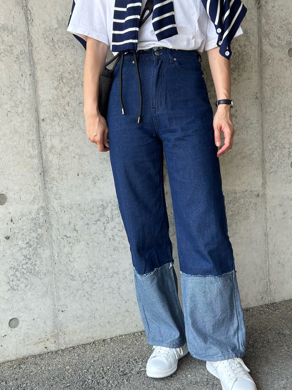 ブルー系のアンサンブル、ブラック系のショルダーバッグ、ブルー系のデニムパンツを着用したレディースの夏コーディネートの3枚目の写真