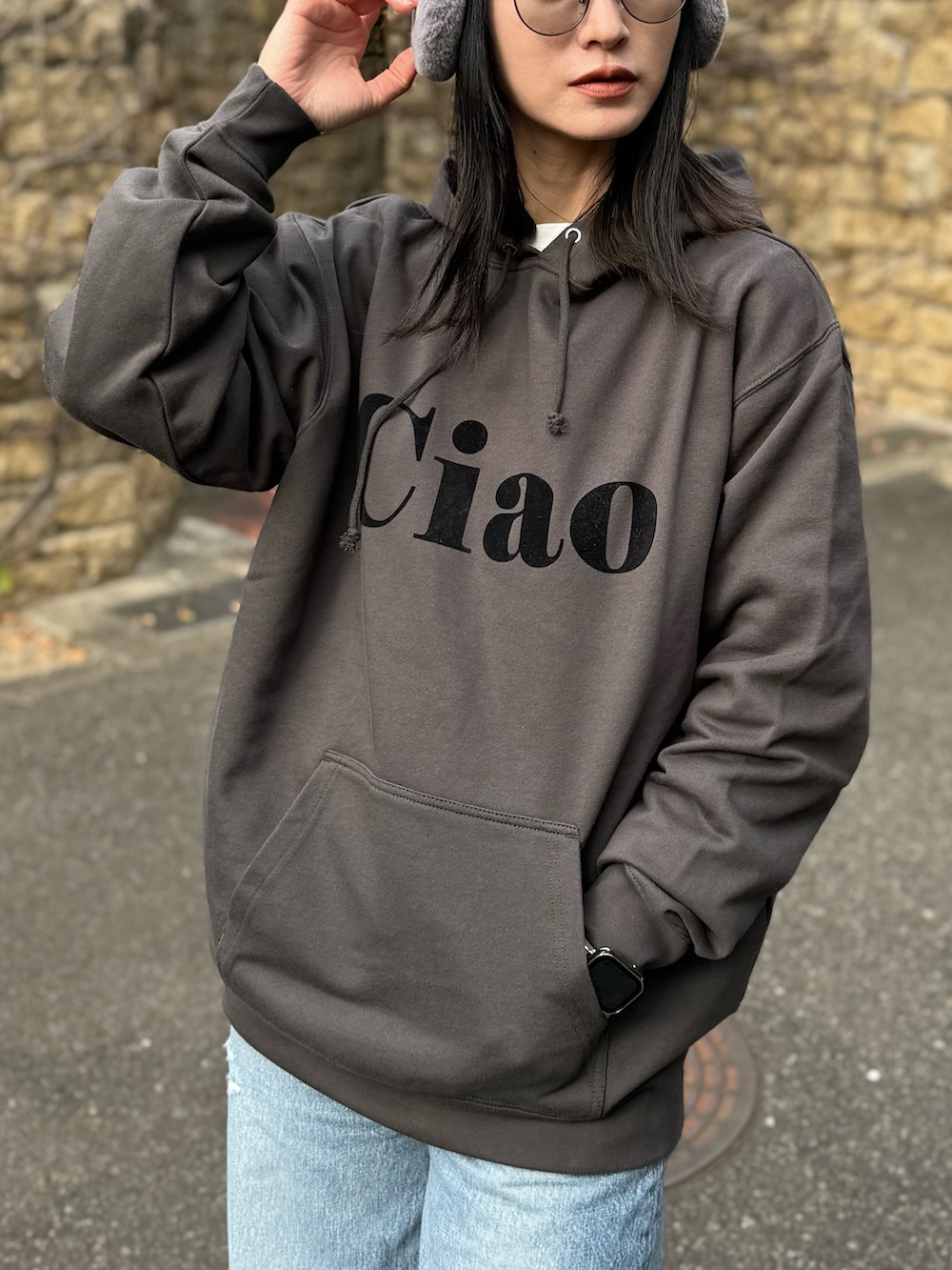 グレー系のパーカー、イエロー系のスリッポン、ブルー系のデニムパンツを着用したレディースの冬コーディネートの3枚目の写真