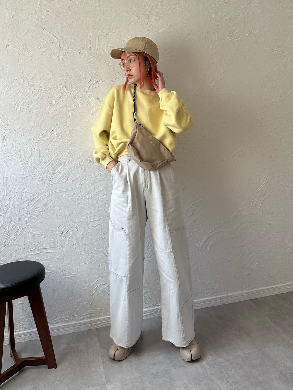 イエロー系のスウェット、ブルー系のデニムパンツ、ベージュ系のスニーカーを着用したレディースの春コーディネートの3枚目の写真