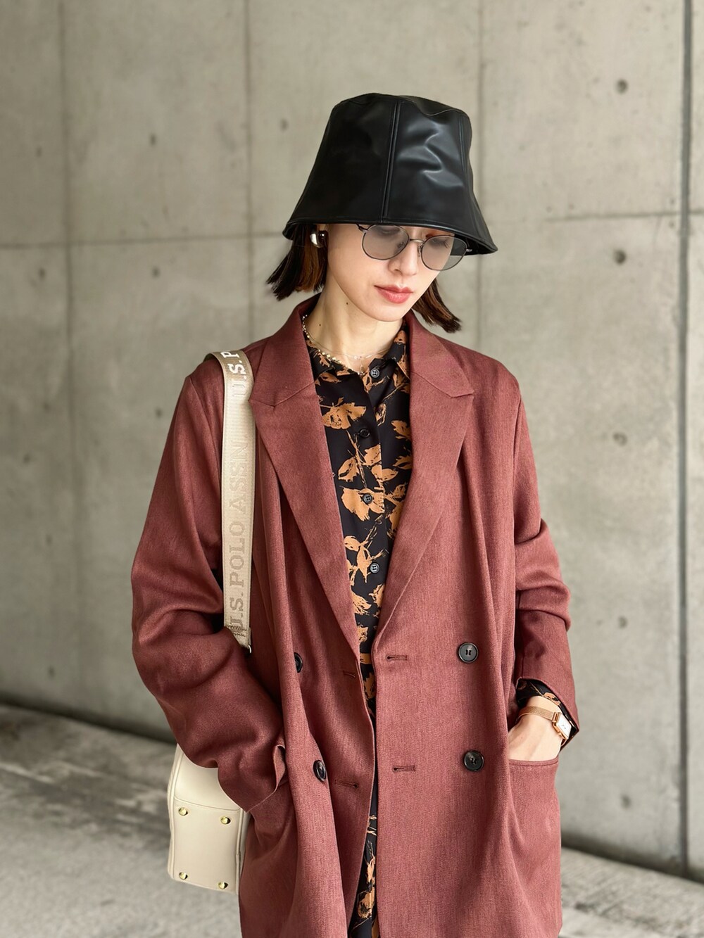 ブラウン系のスーツジャケット、ブルー系のつなぎ/オールインワン、ブラック系のブーツを着用したレディースの秋コーディネートの2枚目の写真