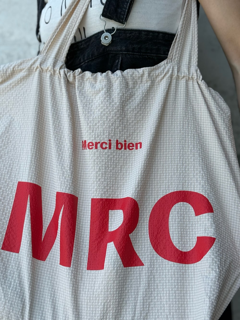 ベージュ系のトートバッグ、ブラック系のサンダルを着用したレディースの秋コーディネートの3枚目の写真